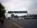 A damaged sign on a lightweight gantry on the Westlink A12 (NI)).