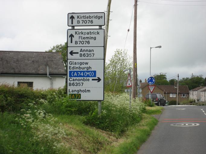 File:Signs at Kirkpatrick Fleming mini-roundabout - Coppermine - 13675.JPG