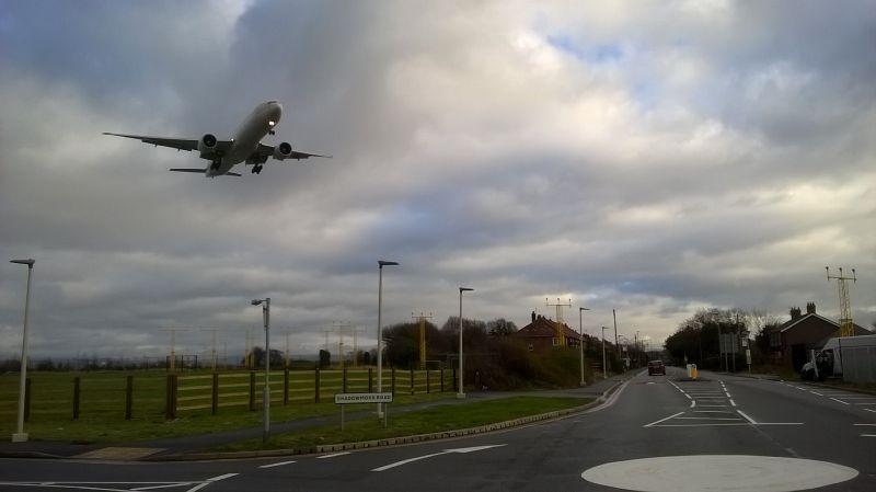 File:20181220-1155 - Junction of Shadow Moss Road and Ringway Road with aeroplane 53.364994N 2.252802W.jpg